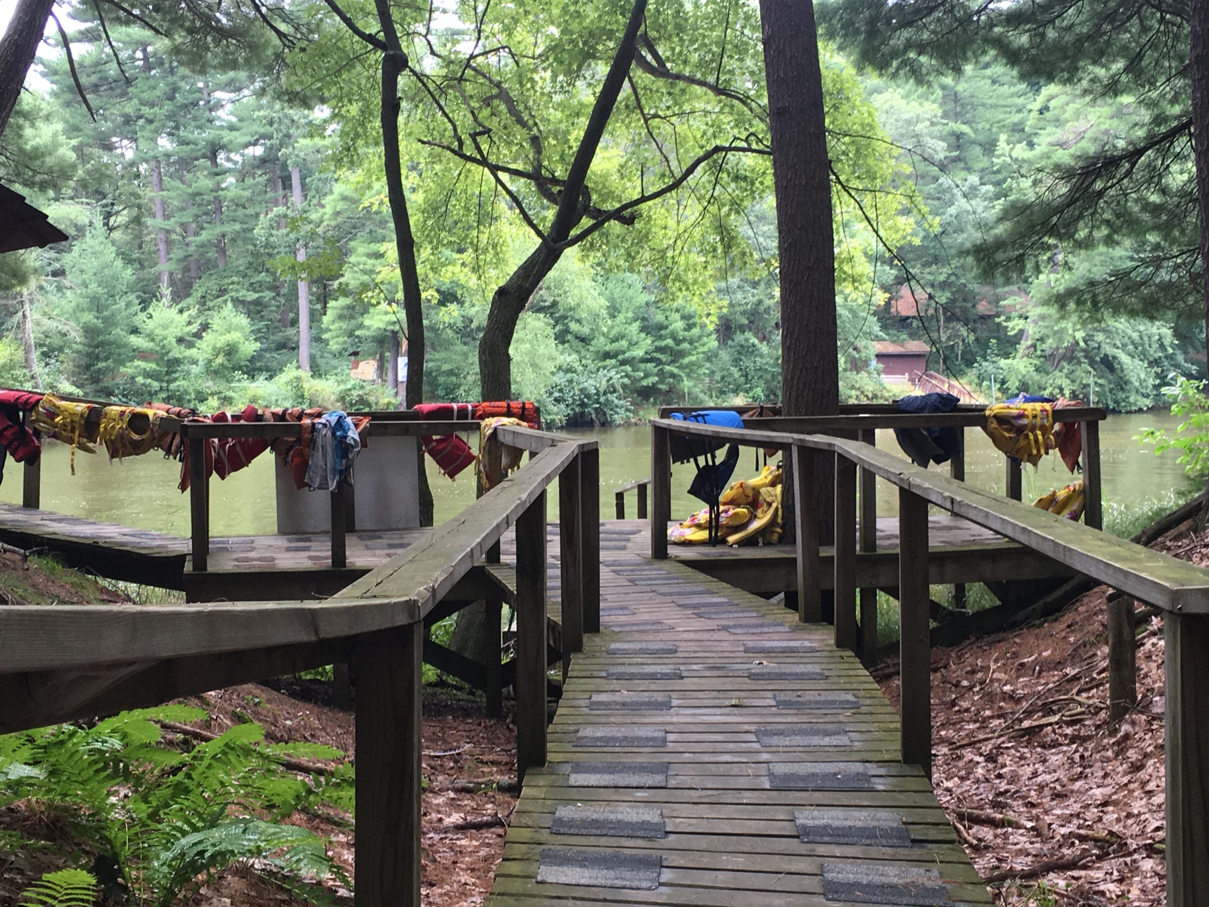Open wooden path with discarded life vests that leads to open water.
