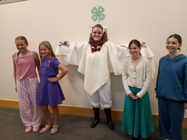 5 youth lined up wearing their Clothing Revue creations