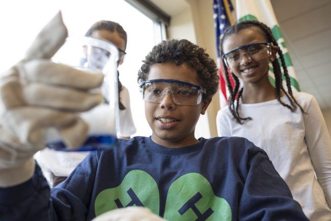 Youth looking at a beaker of blue liquid